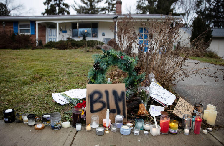 REUTERS/MEGAN JELINGER/FILE PHOTO
Candles burn outside the home where Andre Maurice Hill, 47, was killed in Columbus, Ohio, in December 2020. A former Ohio police officer was convicted of murder by a jury today for fatally shooting Andre Hill, an unarmed Black man.