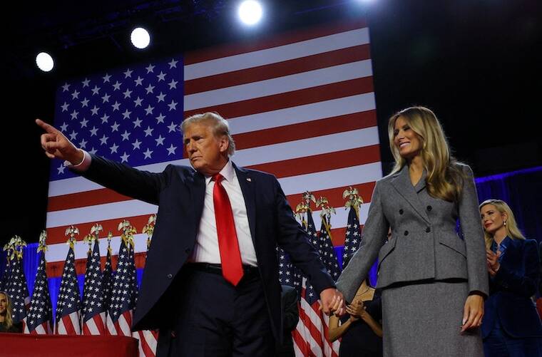 REUTERS/BRIAN SNYDER
Republican presidential nominee and former President Donald Trump gestures as he holds hands with his wife Melania during his rally, at the Palm Beach County Convention Center in West Palm Beach, Fla.