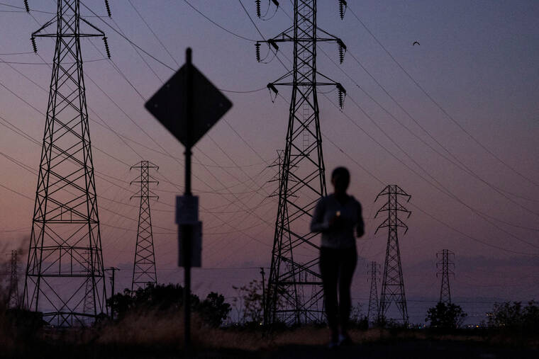 REUTERS/CARLOS BARRIA / 2022
A woman jogs by power lines, as Californias grid operator urged the states 40 million people to ratchet down the use of electricity in homes and businesses as a wave of extreme heat settled over much of the state, in Mountain View, Calif.