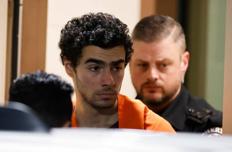 EDUARDO MUNOZ / REUTERS
Luigi Mangione, 26, the suspect in the New York City killing of UnitedHealthcare chief executive Brian Thompson, is escorted after an extradition hearing at Blair County Court House in Hollidaysburg, Pennsylvania, on Dec. 10. He was charged with murder and other offenses today in New York.