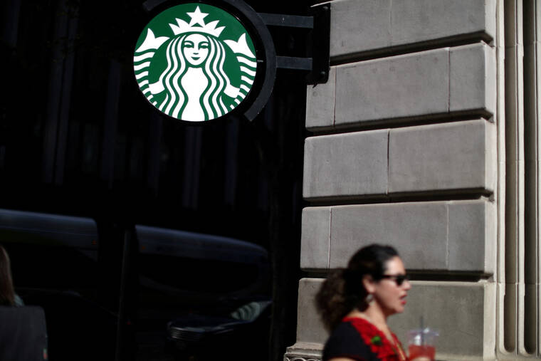 REUTERS/LUCY NICHOLSON / 2018
A woman holds a drink outside a Starbucks store in Los Angeles, Calif.