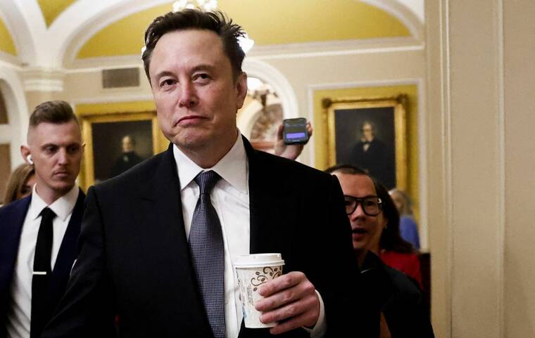 REUTERS/BENOIT TESSIER/FILE PHOTO
Elon Musk walks on Capitol Hill on the day of a meeting with Senate Republican Leader-elect John Thune (R-SD), in Washington, on Dec. 5. Musk, tapped by President-elect Donald Trump to prune the federal government, today pressured Republicans in Congress to reject a stopgap spending bill, which would trigger a partial government shutdown.