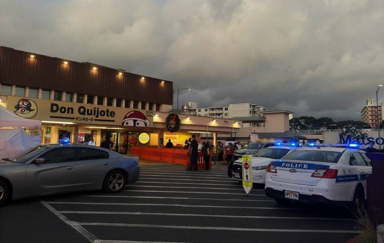 VICTORIA BUDIONO / VBUDIONO@STARADVERTISER.COM
Onlookers and police are seen outside the Don Quijote supermarket on Kaheka Street Wednesday evening as a barricade situation forced the store to close.