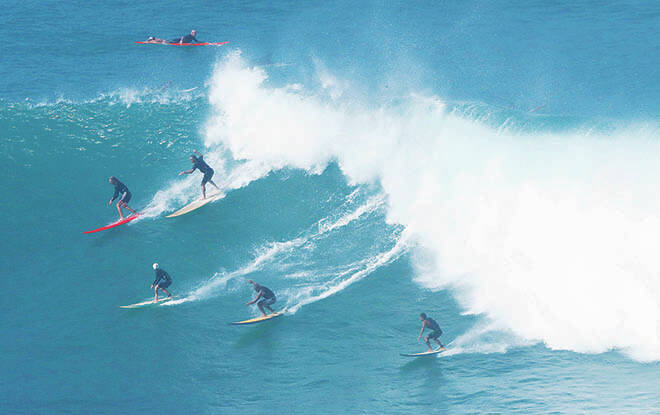 JAMM AQUINO / JAQUINO@STARADVERTISER.COM
Surfers take off on a wave at Waimea Bay Friday on Oahus North Shore.